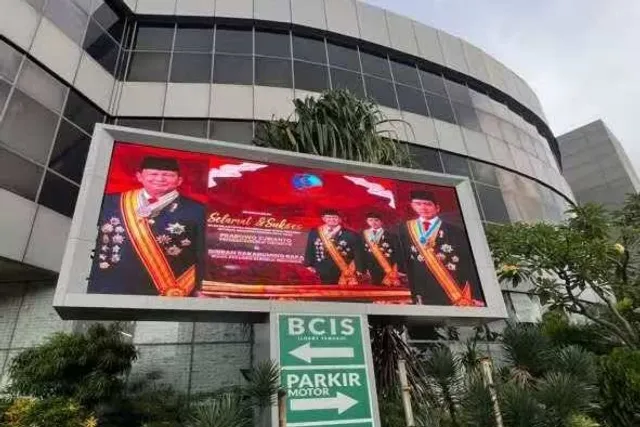 Videotron P8 berdiri di taman depan gedung kawasan Ancol Jakarta Utara, menayangkan konten seremonial berlatar merah