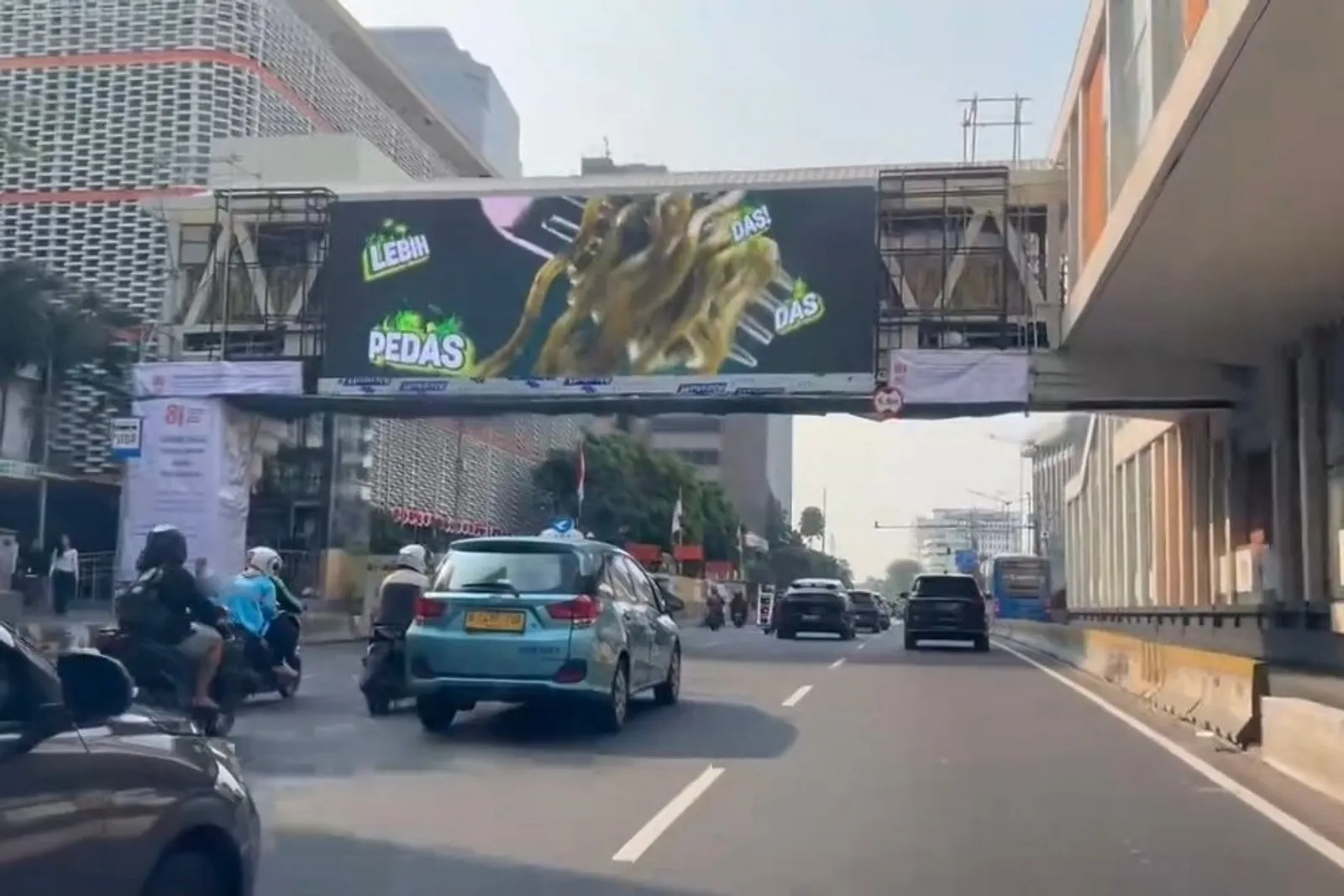 LED bando P6.67 melintang di atas Jalan M.H. Thamrin Jakarta menayangkan iklan makanan, dilihat dari jalur kendaraan