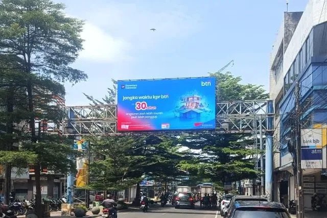 LED bando P6.67 melintang di atas Jalan Jenderal Sudirman Bandung menayangkan iklan KPR bank pada siang hari