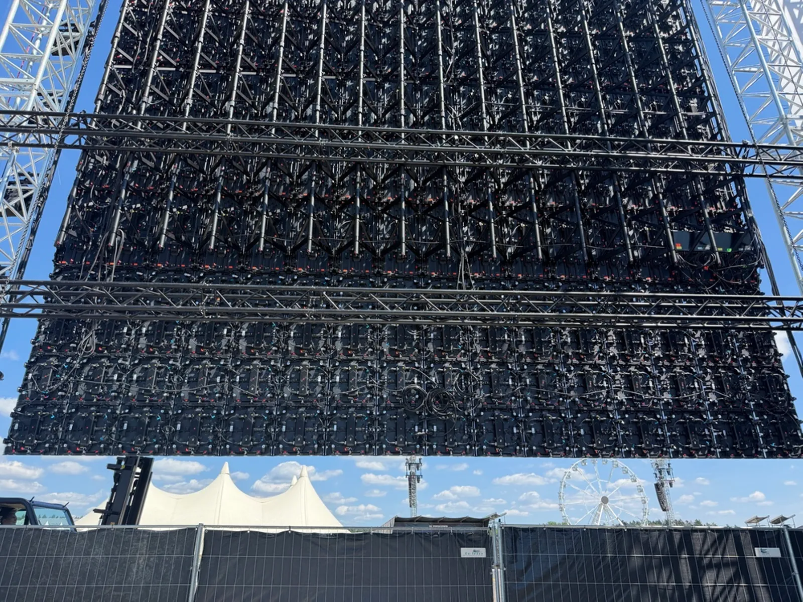 Kru memasang kabinet LED Master Pro Touring pada rigging panggung festival