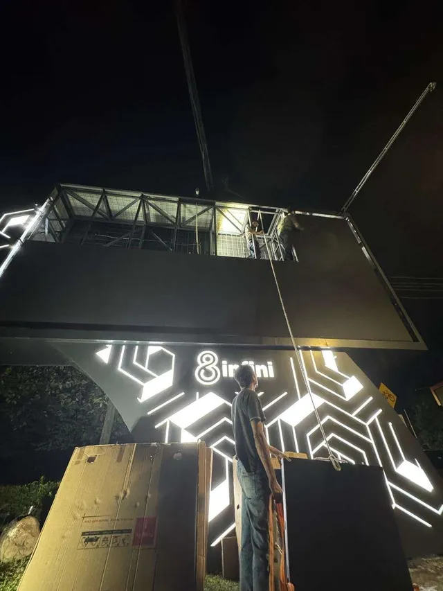 Teknisi memasang panel instalasi cahaya di struktur videotron kawasan Senopati pada malam hari