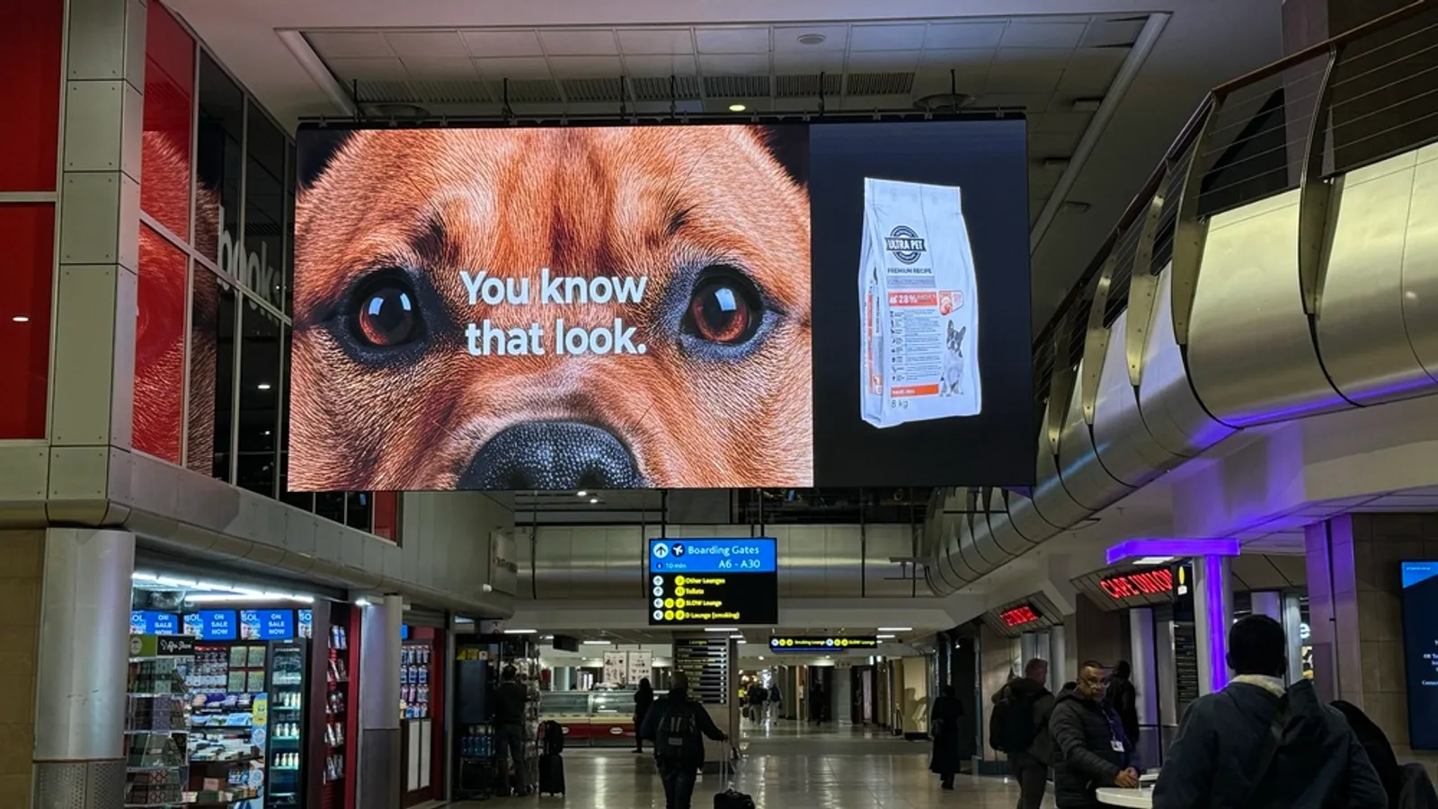 Layar iklan LED tergantung dari langit-langit terminal bandara O.R. Tambo