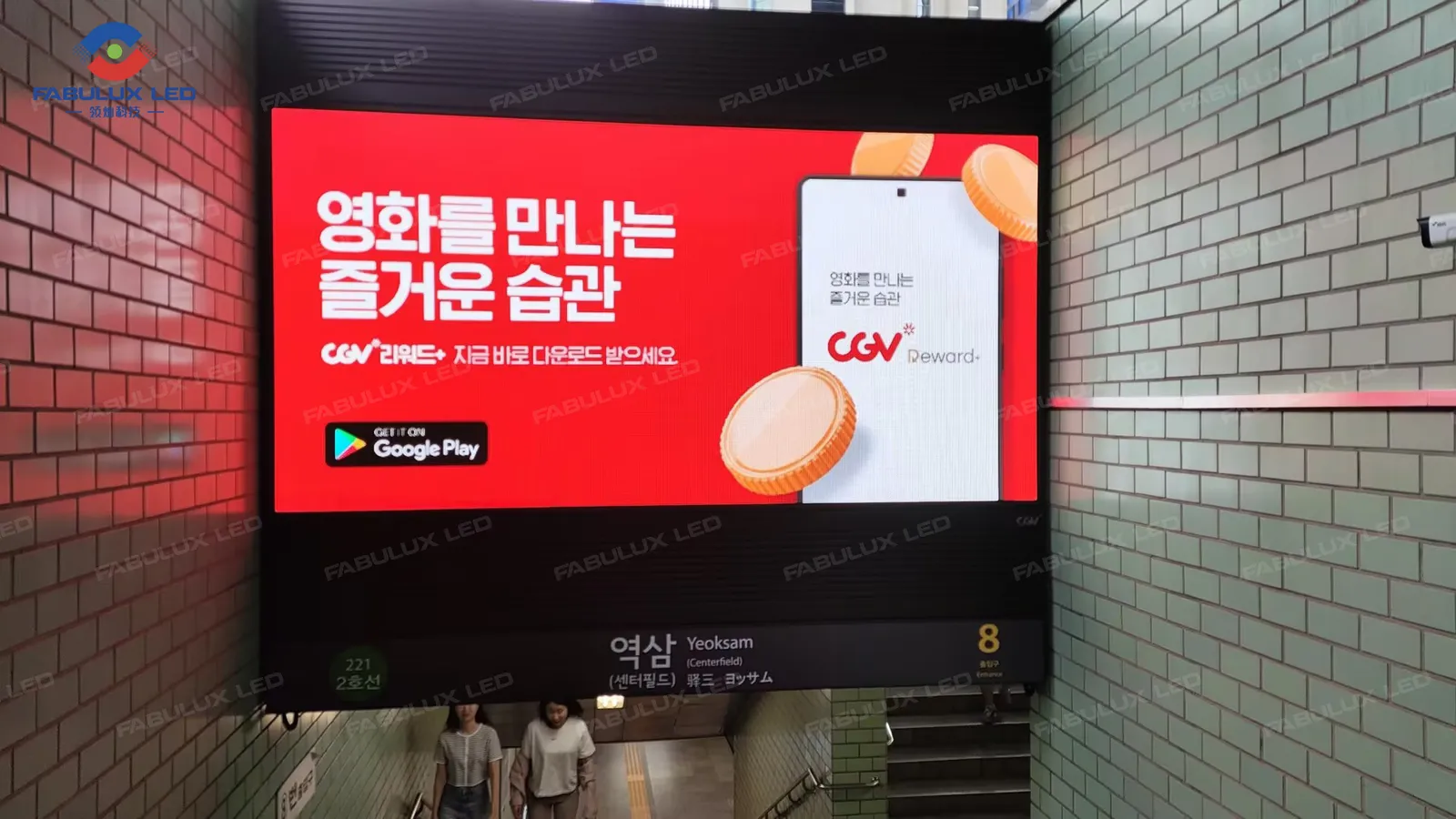 Layar LED pintu keluar stasiun metro Korea menampilkan konten iklan